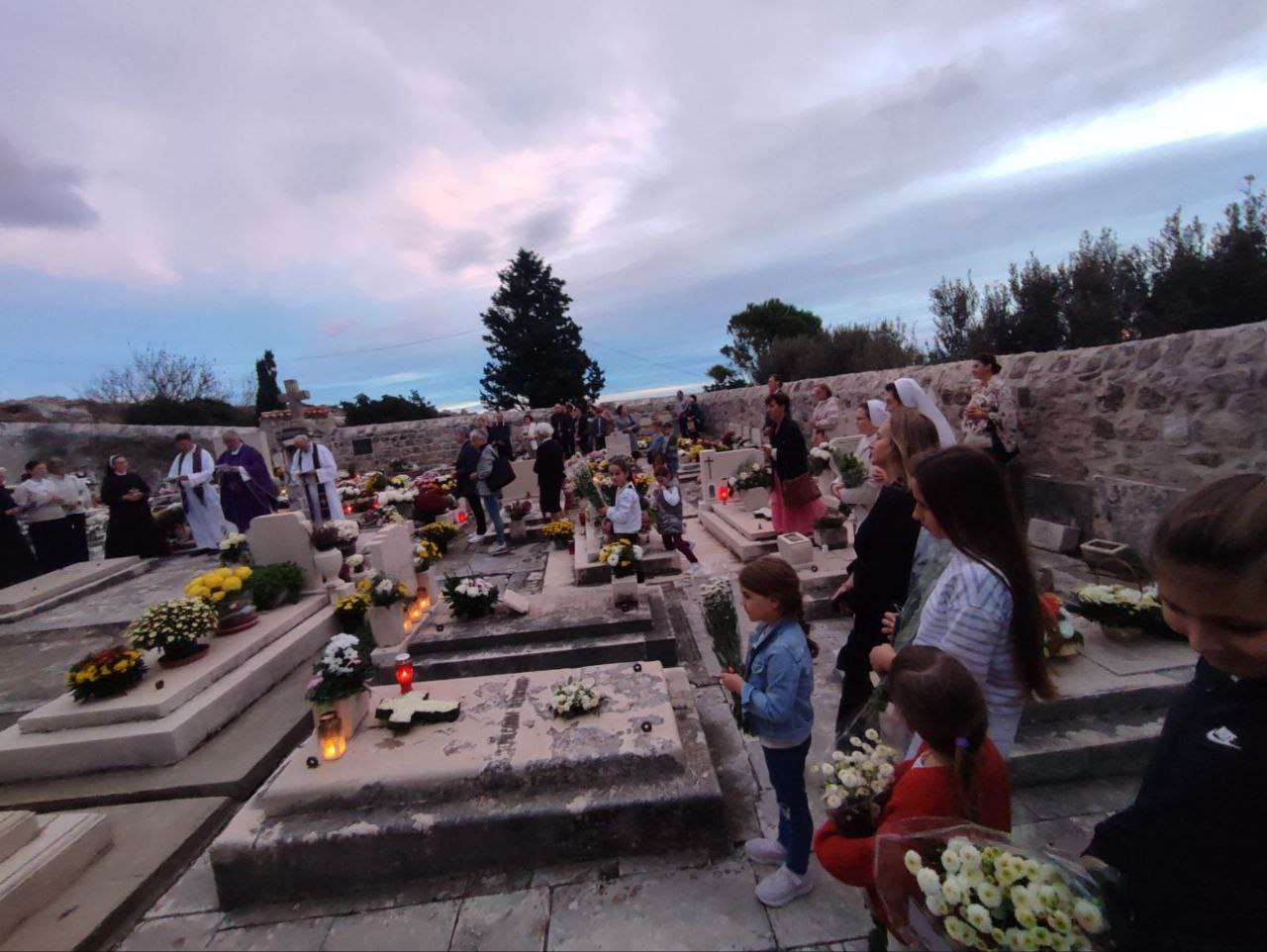 Akcija “Sjetimo se” na Dančama: Djeca i redovnice okitili grobove i pomolili se za pokojne