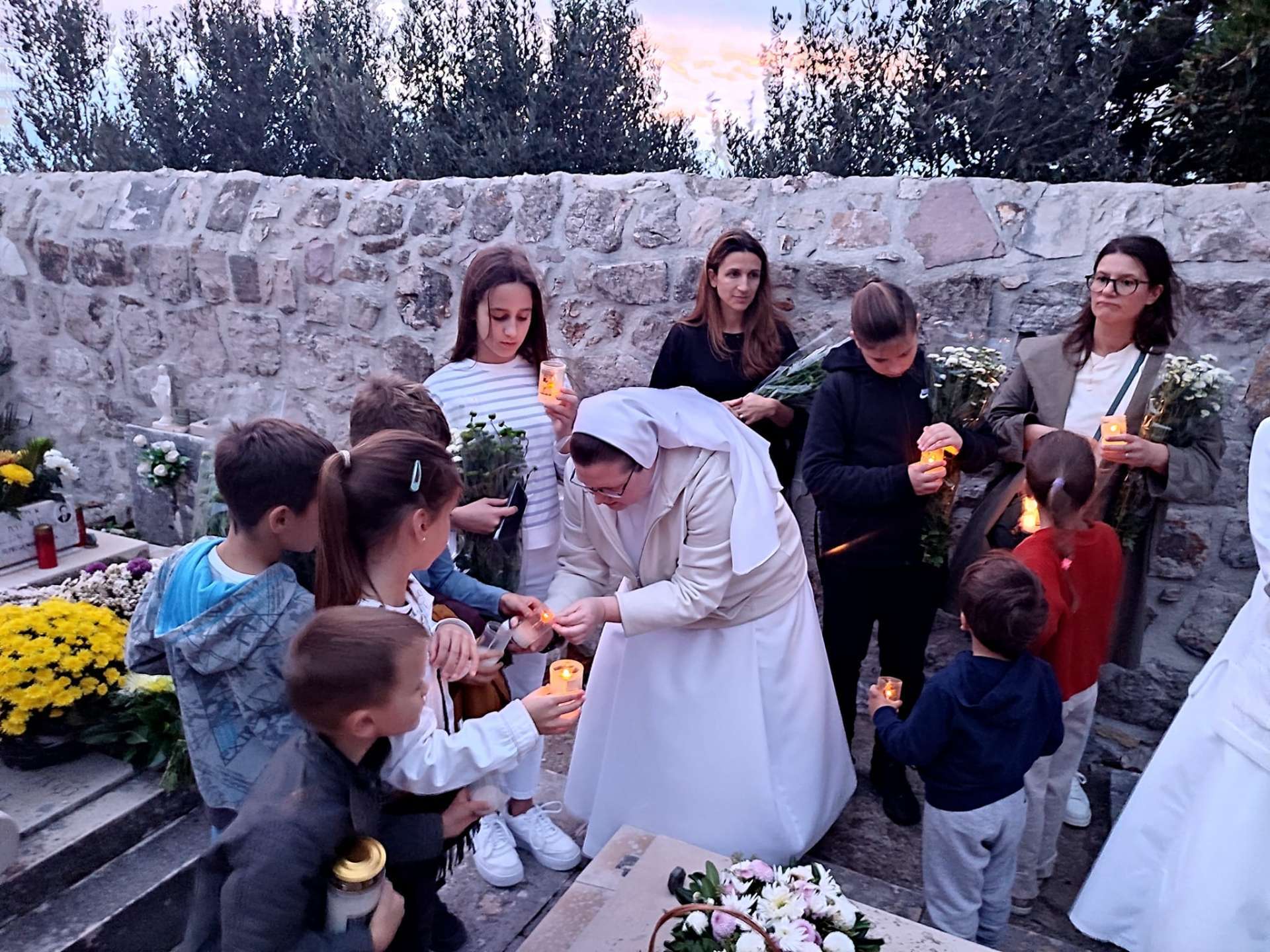 Akcija “Sjetimo se” na Dančama: Djeca i redovnice okitili grobove i pomolili se za pokojne