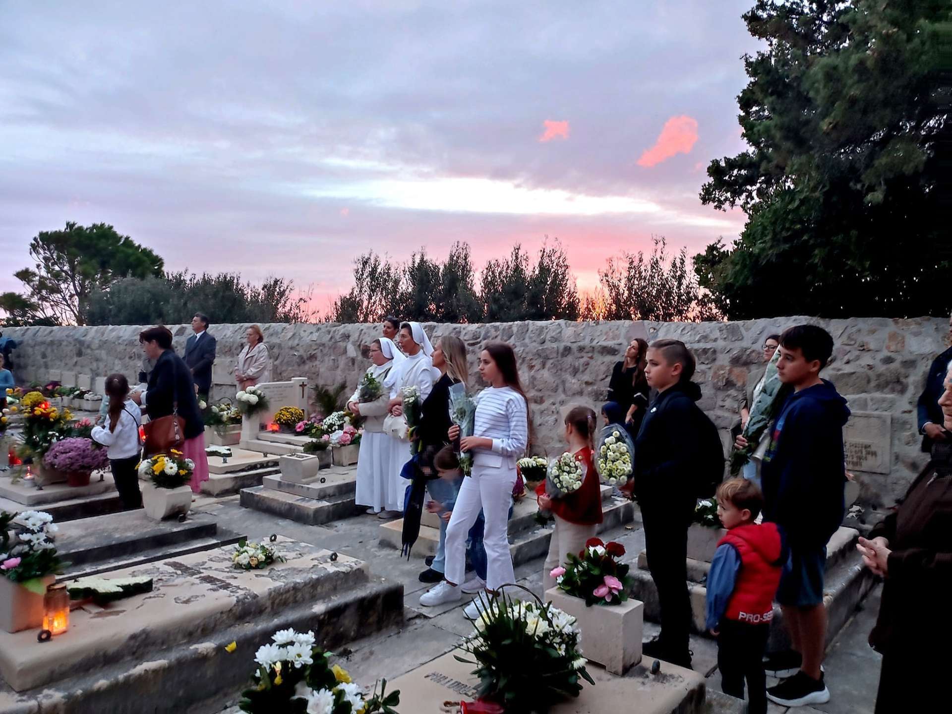 Akcija “Sjetimo se” na Dančama: Djeca i redovnice okitili grobove i pomolili se za pokojne